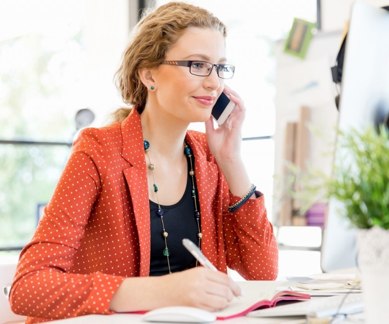 young-woman-holding-mobile-phone-in-office-PE9ARDR-1024x853
